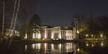 Das Dieselkraftwerk Cottbus bei Nacht, gespiegelt im Amtsteich