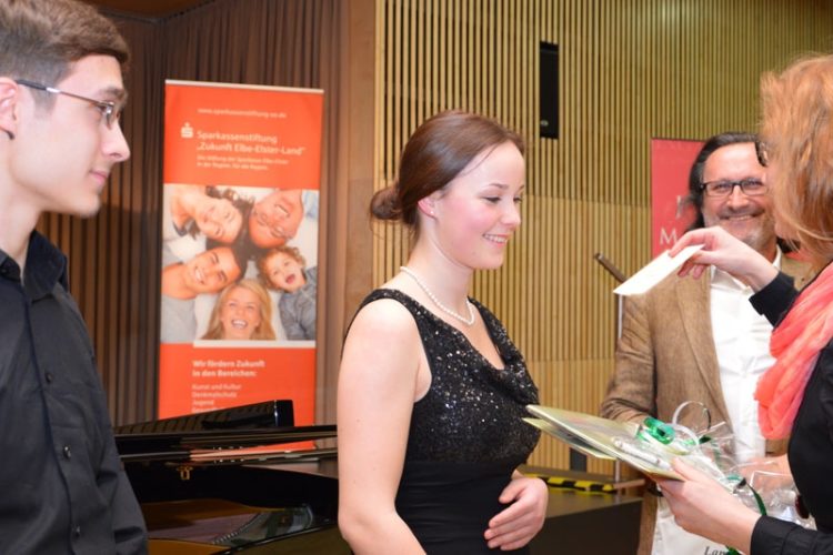 Kämmerin Anja Zajic (r) überreicht den Sonderpreis an Laura Wagner (m) und Armin Moriabadi (l). Im Hintergrund Musikschulleiter Thomas Prager.