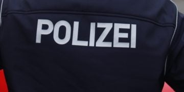 Polizist mit Polizei-Schriftzug auf der Einsatzjacke (Symbolbild)