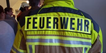Feuerwehr-Einsatzjacke von hinten vor Publikum (Symbolbild)