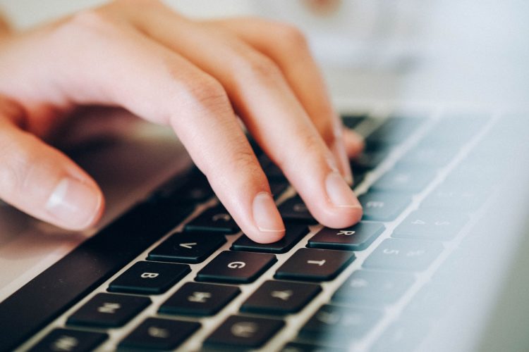 Hand auf der Tastatur eines Laptops