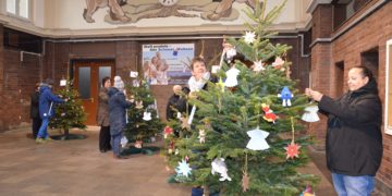 DRK Mitarbeiter beim schmücken der Bäume im Senftenberger Bahnhof