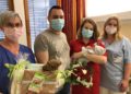 Hebamme Ines Linse und Pflegeschülerin Phoebe Richter überreichen den glücklichen Eltern ein Präsent des Carl-Thiem-Klinikums
