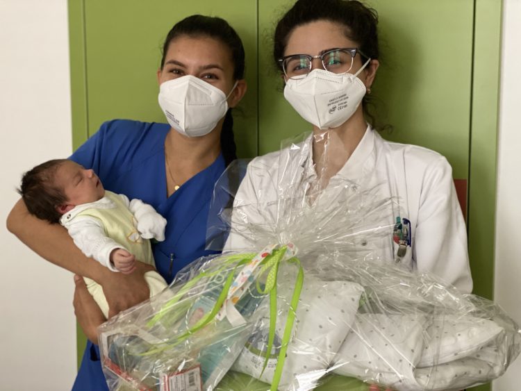 Hebamme Yasmina Zemouri und Ärztin Inessa Tsaturyan mit der kleinen Mia und einem CTK-Begrüßungsgeschenk (Bild: CTK)