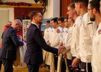Sachsens Ministerpräsident Michael Kretschmer gratuliert zusammen mit Domowina-Vorsitzendem Dawid Statnik den Spielern der sorbischen Mannschaft, dem ganzen Team und Fans bei Dankesveranstaltung am Freitagabend im Sorbischen Kulturzentrum Schleife. Foto: Jörg Stephan