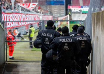 Polizeikräfte gehen im Stadion der Freundschaft in Cottbus an einem Fanblock entlang