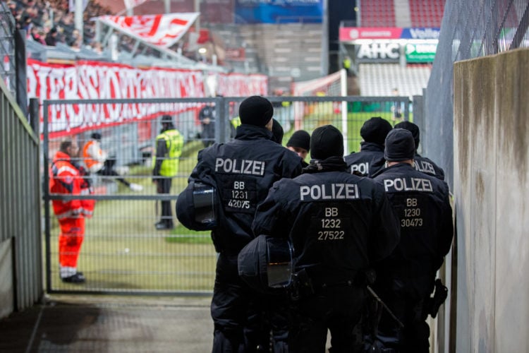 Polizeikräfte gehen im Stadion der Freundschaft in Cottbus an einem Fanblock entlang