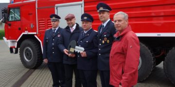 Im Beisein von Amtswehrführer Marcus Weber (l.) und dem Vorsitzenden des Amtsausschusses, Joachim Dieke (r.) übergibt Amtsdirektor Tobias Hentschel (2. v. l.) den symbolischen Fahrzeugschlüssel für das hinter ihnen stehende GTLF an Gerätewart Jens Buder (m.) und Ortswehrführer Daniel Scheiter. (Foto: K. Möbes)