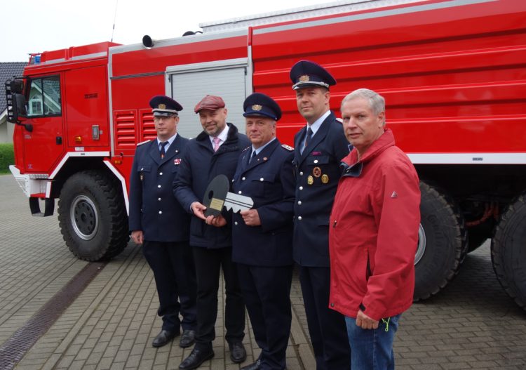 Im Beisein von Amtswehrführer Marcus Weber (l.) und dem Vorsitzenden des Amtsausschusses, Joachim Dieke (r.) übergibt Amtsdirektor Tobias Hentschel (2. v. l.) den symbolischen Fahrzeugschlüssel für das hinter ihnen stehende GTLF an Gerätewart Jens Buder (m.) und Ortswehrführer Daniel Scheiter. (Foto: K. Möbes)