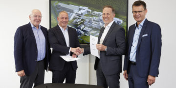 Vertreter von Rock Tech Lithium und LEAG vor einer Visualisierung des Lithium-Konverters Guben