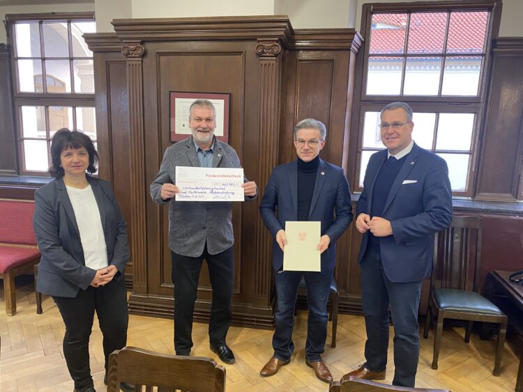 Rainer Genilke (r.) übergibt den Fördermittelscheck an Susan Schüler, Frank Zimmermann und Jörg Gampe (v.l.). (Foto ©: Kai Roeper)