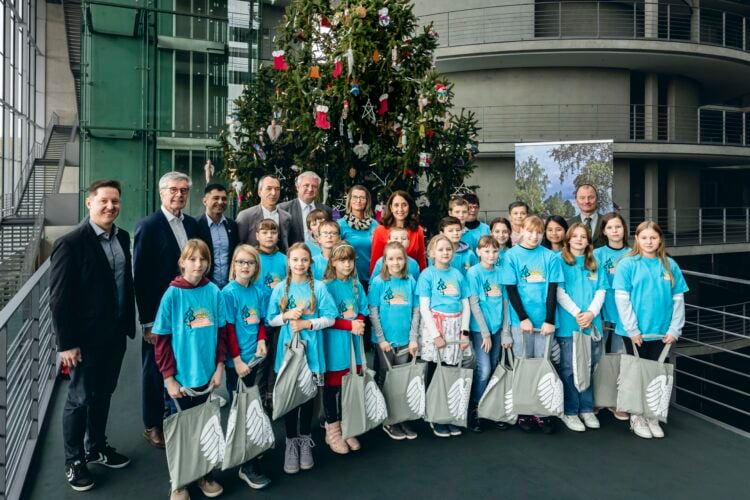 Die Schülerinnen und Schüler der Naturpark-Grundschule Rückersdorf übergeben einen Weihnachtsbaum an den Deutschen Bundestag (Quelle: Deutscher Bundestag / Xander Heinl)