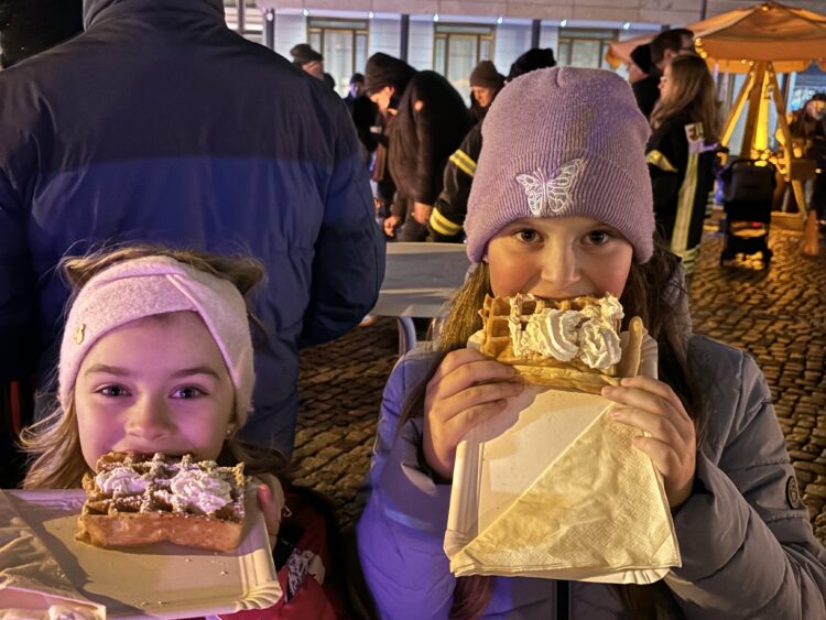 Heidi und Kate lassen es sich schmecken beim ersten Senftenberger Wünschefest auf dem Markt. Beim Waffel-Test geht ihr Daumen eindeutig nach oben. (Bild: Andrea Budich)