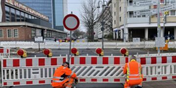Bauarbeiter stellen Absperrbaken für eine Vollsperrung auf – Symbolbild
