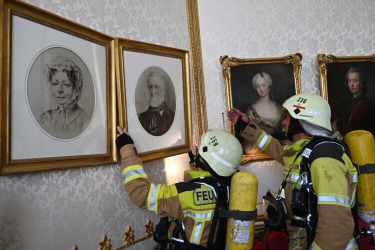 Demonstration einer Kulturgutbergung: Feuerwehrteam nimmt im Schloss Branitz eine historische Fotografie ab © Michael Helbig