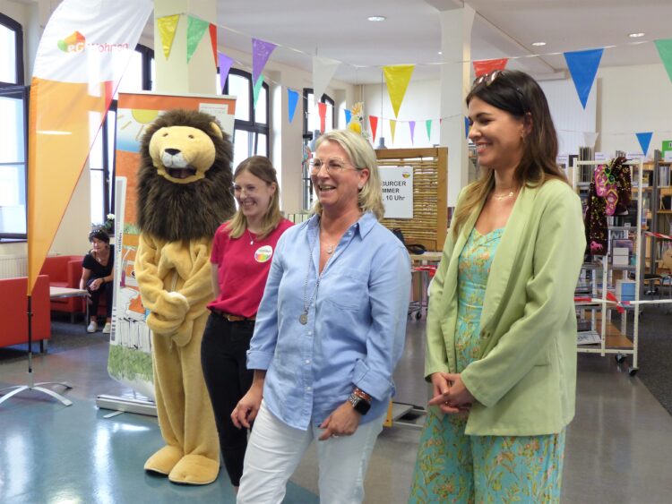 Große Freude über die beeindruckende Resonanz bereits am Eröffnungstag: v.l.: Leselöwe, Kinderbibliothekarin Pauline Blum, Schirmherrinnen der „eG Wohnen 1902“ Jeanette Oelmann und Sarah Tondera (Bild: Uta Jacob)