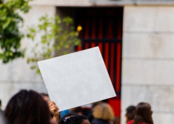 Sign with white copy space for your text hold by young millennial activist in strike