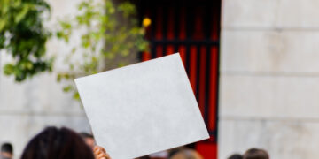 Sign with white copy space for your text hold by young millennial activist in strike