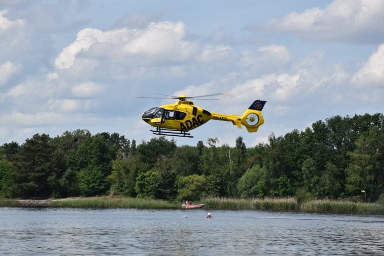 Der ADAC-Rettungshubschrauber wirft in der Nähe des Übungs-Notfalls eine selbstaufblasende Rettungsboje ab (Bild: DRK-KV Lausitz/Dunja Petermann)