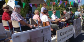 Zur Geschichte von Burg-Kauper gehören die einstmals zwei Schulen. Der ehemalige Schulleiter und Lehrer der 2. Kauperschule Klaus Haufe (r.) hat beim Heimat- und Trachtenfest ehemalige Schülerinnen und Schüler auf den Festwagen eingeladen. (Foto: K. Möbes)