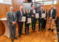 Die Berufenen sind Prof. Dr. Georg Christof Schwabe (2.v.l.), Prof. Dr. Franziska Bathelt (3.v.l.), Prof. Dr. Johannes Beller (4.v.l.) und Prof. Dr. Pavel Strnad (3.v.r.). Flankiert werden sie vom kaufmännischen Vorstand und stellv. Vorstandsvorsitzenden der MUL – CT, Dr. Alexander Hewer (l.), der Gründungsvorständin Wissenschaft, Prof. Dr. Adelheid Kuhlmey (2.v.r.) und dem Digitalisierungsvorstand Martin Peuker (r.). (Bild: Martin Ender / MUL CT)