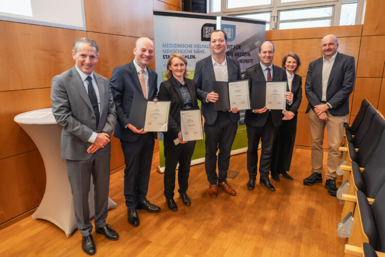 Die Berufenen sind Prof. Dr. Georg Christof Schwabe (2.v.l.), Prof. Dr. Franziska Bathelt (3.v.l.), Prof. Dr. Johannes Beller (4.v.l.) und Prof. Dr. Pavel Strnad (3.v.r.). Flankiert werden sie vom kaufmännischen Vorstand und stellv. Vorstandsvorsitzenden der MUL – CT, Dr. Alexander Hewer (l.), der Gründungsvorständin Wissenschaft, Prof. Dr. Adelheid Kuhlmey (2.v.r.) und dem Digitalisierungsvorstand Martin Peuker (r.). (Bild: Martin Ender / MUL CT)