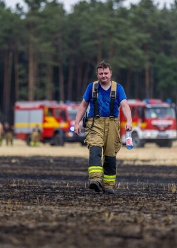 Feuerwehrmann löscht den Feldbrand bei Drochow