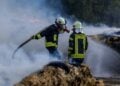Einsatzkräfte löschen brennende Strohballen in Großkmehlen