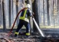 Feuerwehrmann mit Strahlrohr im Wald bei Halbe
