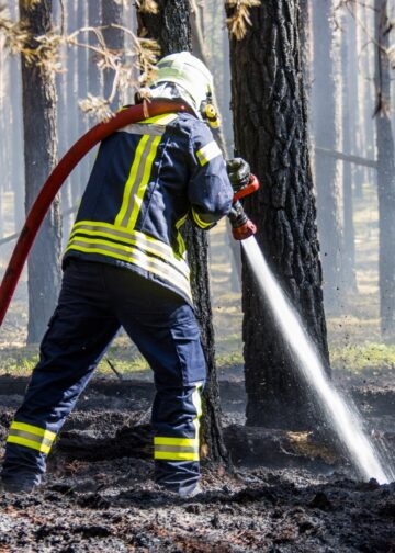 Feuerwehrmann mit Strahlrohr im Wald bei Halbe