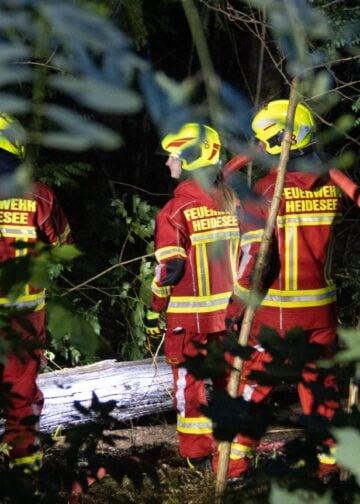Einsatzkräfte kontrollieren den Brandbereich in Heidesee