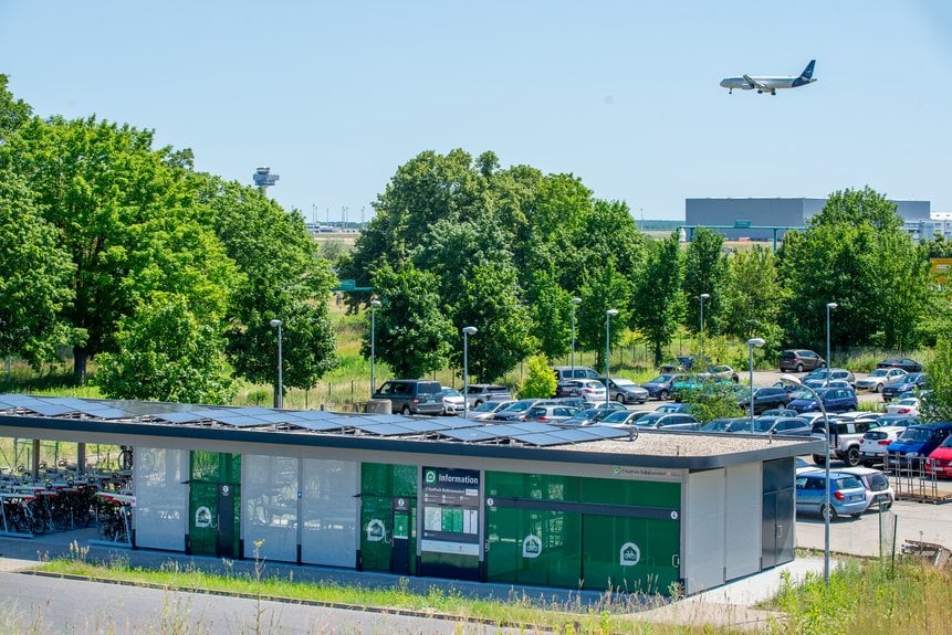 RadPark Waßmannsdorf mit Solardach und landendem Flugzeug am BER
