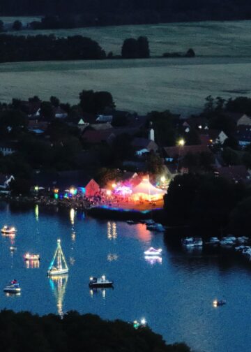 Beleuchtete Boote und Festgelände bei der Nacht der 1000 Lichter in Goyatz