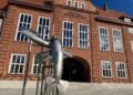 Backsteinfassade des Stadthauses in Cottbus mit Skulptur auf dem Vorplatz