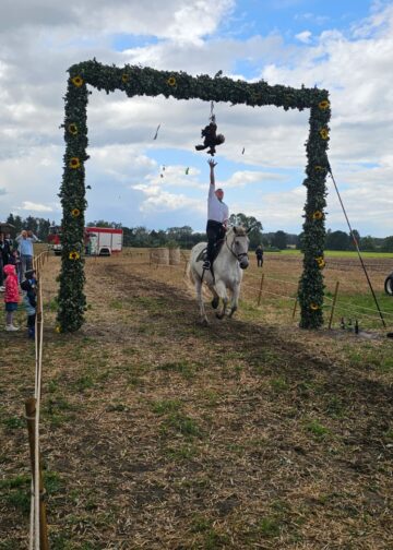 Reiter an der geschmückten Pforte beim Ströbitzer Erntefest