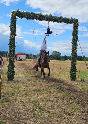 Reiter greift beim Hahnrupfen in Ströbitz nach dem Kranz