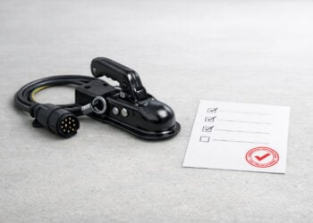 Anhängerkupplung mit 13-poligem Stecker neben abgehakter Prüf-Checkliste