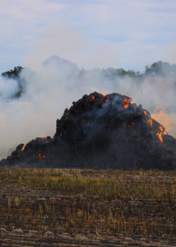 Brennender Strohballen auf einem Feld in Spree-Neiße
