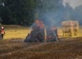 Einsatzkräfte an den brennenden Strohballen