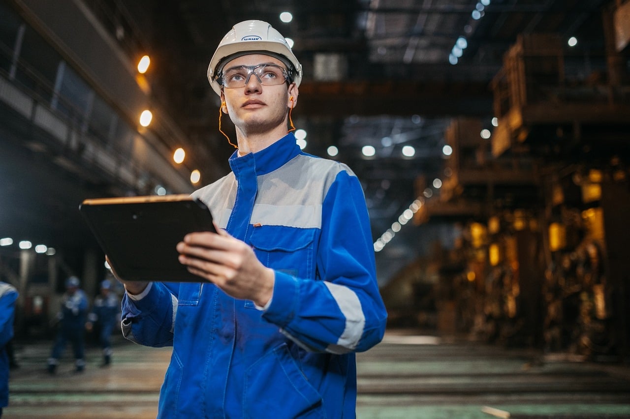 Techniker mit Schutzhelm und Tablet in einer Industrieanlage