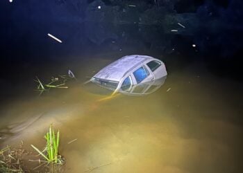 Halb versunkenes Auto nachts im Wasser der Neiße