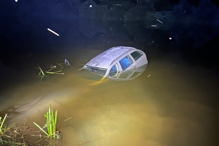 Halb versunkenes Auto nachts im Wasser der Neiße