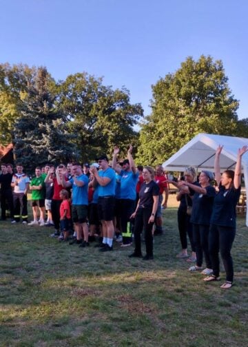 Teilnehmerinnen und Teilnehmer jubeln auf dem Sportplatz