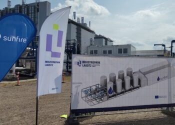 Fahnen von Sunfire und Industriepark Lausitz am Bauzaun in Schwarzheide