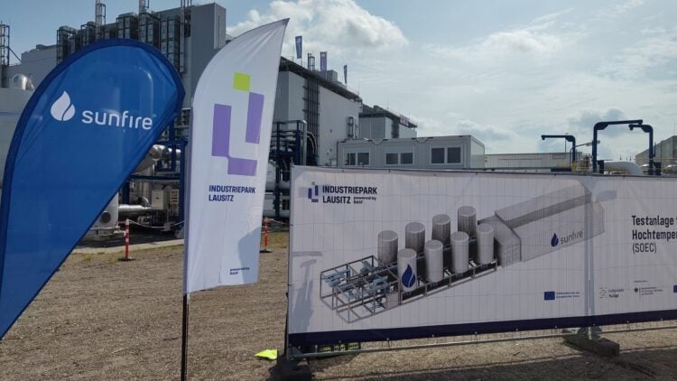 Fahnen von Sunfire und Industriepark Lausitz am Bauzaun in Schwarzheide