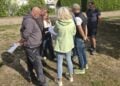 Gruppe von Menschen mit Plänen auf der künftigen Fläche des Multicourts am Kiebitzsee