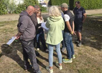 Gruppe von Menschen mit Plänen auf der künftigen Fläche des Multicourts am Kiebitzsee