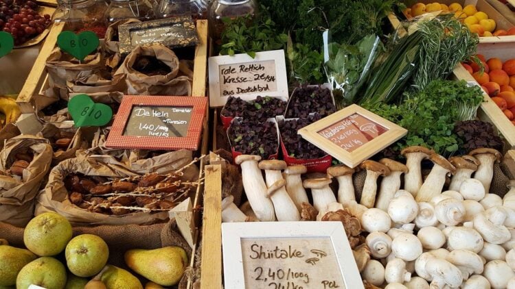 Marktstand mit Gemüse, Pilzen und Obst in Holzkisten