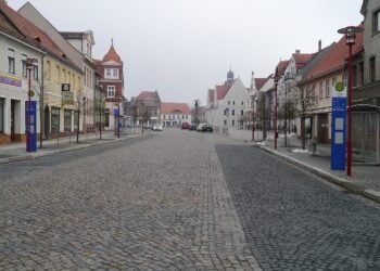 Blick über den gepflasterten Marktplatz von Doberlug-Kirchhain mit Wohn- und Geschäftshäusern