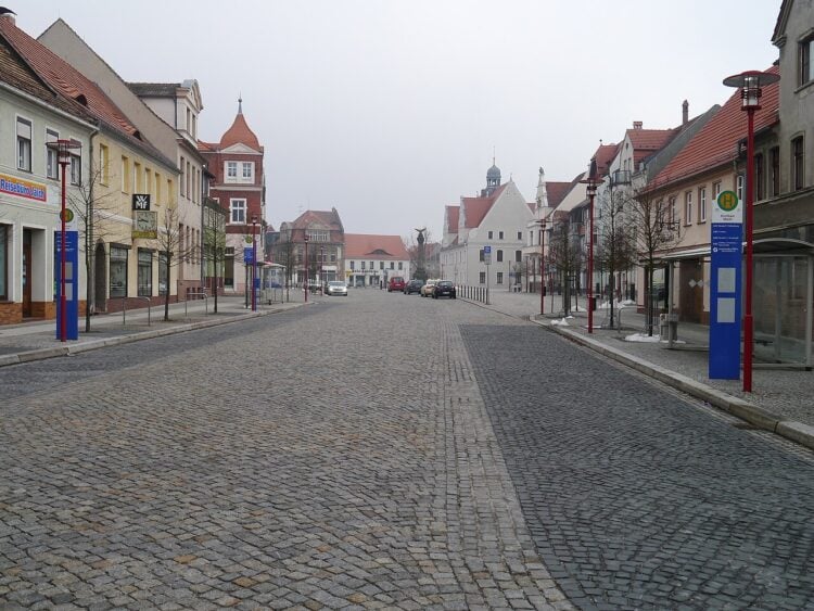 Blick über den gepflasterten Marktplatz von Doberlug-Kirchhain mit Wohn- und Geschäftshäusern